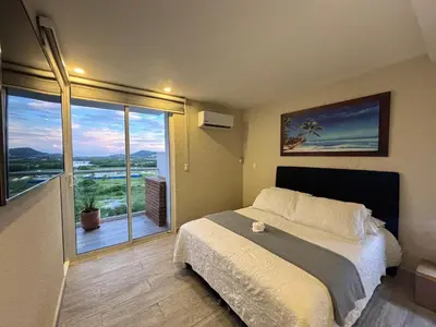 a bedroom with a large bed and a large window at Apartamento lujoso en Cartagena con jacuzzi y piscina privada in Cartagena de Indias