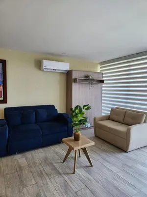 a living room with a blue couch and a table at Apartamento lujoso en Cartagena con jacuzzi y piscina privada in Cartagena de Indias