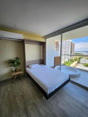 a bedroom with a bed and a large window at Apartamento lujoso en Cartagena con jacuzzi y piscina privada in Cartagena de Indias
