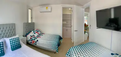 a bedroom with two beds and a flat screen tv at 2 Bedroom Beachfront Apartment 2P1-Al4 With Pool And WIFI in Cartagena de Indias