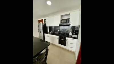 a kitchen with white cabinets and a black counter top at 2 Bedroom Beachfront Apartment 2P1-Al4 With Pool And WIFI in Cartagena de Indias