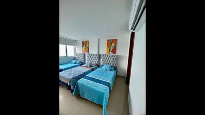 a bedroom with two beds with blue comforters at 2 Bedroom Beachfront Apartment 2P1-Al2 With Pool And WIFI in Cartagena de Indias