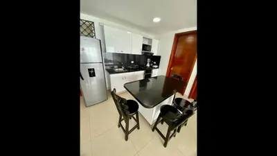 a kitchen with a table and two chairs and a refrigerator at 2 Bedroom Beachfront Apartment 2P1-Al With Pool And WIFI in Cartagena de Indias