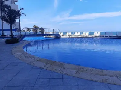a large blue swimming pool with a bridge over it at 2 Bedroom Beachfront Apartment 2P1-Al With Pool And WIFI in Cartagena de Indias