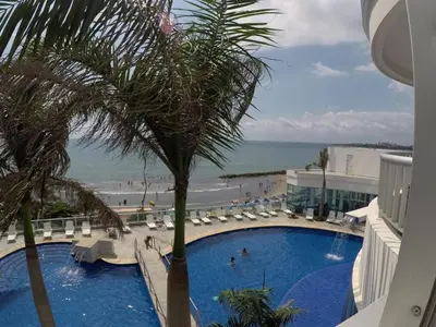 a swimming pool with a palm tree and the beach at 2 Bedroom Beachfront Apartment 2P1-Al With Pool And WIFI in Cartagena de Indias