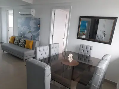 a living room with a couch and a table and a mirror at 2 Bedroom Beachfront Apartment in Cartagena de Indias