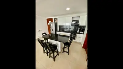 a kitchen with a black table and black chairs at 2 Bedroom Beachfront Apartment in Cartagena de Indias