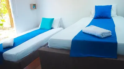 two beds sitting next to a window in a room at Linda cabaña en Isla Tierra Bomba frente a Cartagena in Cartagena de Indias