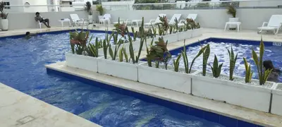 a swimming pool with blue water and plants in it at Apartamento Amoblado Cartagena in Cartagena de Indias