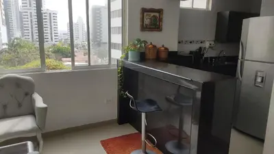 a kitchen with a black counter and a refrigerator at Apartamento Amoblado Cartagena in Cartagena de Indias