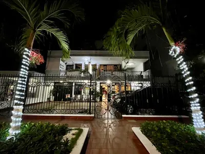 a building with a gate and palm trees at night at Hotel Boutique Casa Pere in Cartagena de Indias