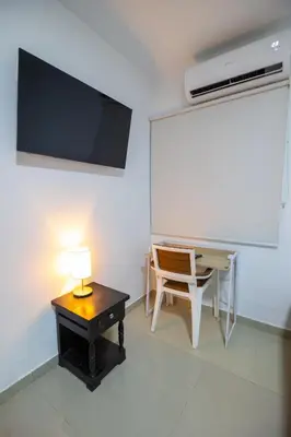 a room with a desk and a table with a lamp at Hotel Boutique Casa Pere in Cartagena de Indias