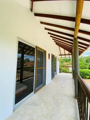 a porch of a house with large glass doors at Cabaña cerca al Mar con Pisicina y AC en Tolú in Tolú