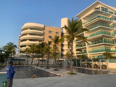 a man standing next to a swimming pool in front of a building at Apartamento Morros 922 in Cartagena de Indias
