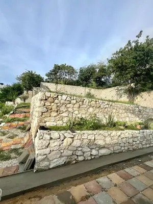 a stone retaining wall with a garden on it at Casa Hotel Isabella in Santa Marta