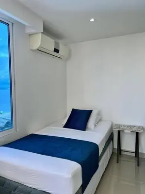 a white room with a bed and a window at Relax y Confort - Apartamento frente al Mar in Cartagena de Indias