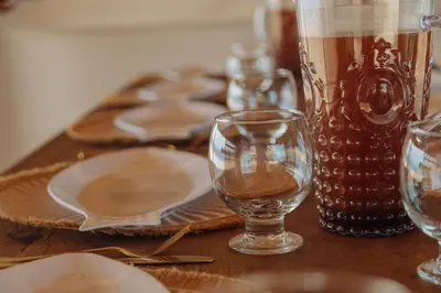 a wooden table with plates and glasses on it at Isla Kalua - Private Ocean Villa in Isla Pavitos