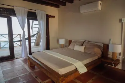 a bedroom with a bed and a large window at Isla Kalua - Private Ocean Villa in Isla Pavitos