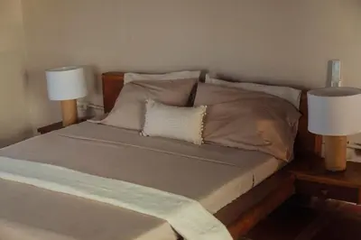 a bedroom with a bed with two lamps on it at Isla Kalua - Private Ocean Villa in Isla Pavitos