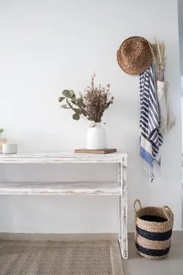a white console table with a vase of flowers on it at Condominio frente al mar con acceso directo a la playa Morros Epic. in Cartagena de Indias