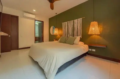 a bedroom with a large bed and a green wall at Condominio frente al mar con acceso directo a la playa Morros 922 in Cartagena de Indias