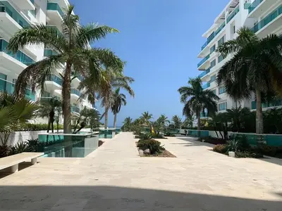 a resort corridor with palm trees and a building at Condominio frente al mar con acceso directo a la playa Morros 922 in Cartagena de Indias
