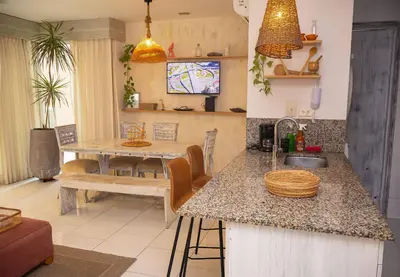 a kitchen with a counter with a sink and a table at Condominio frente al mar con acceso directo a la playa Morros 922 in Cartagena de Indias