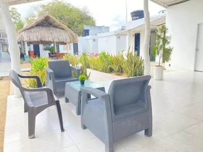 a patio with chairs and a table and a umbrella at Hostal El Danubio Tolu in Tolú