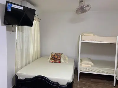 a room with a bed and a tv on a wall at Casa ISABELLA - Playa dormida in Santa Marta