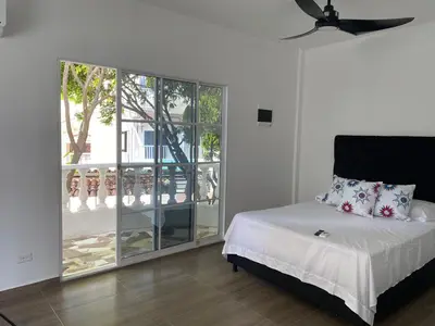 a bedroom with a bed and a large glass window at Casa ISABELLA - Playa dormida in Santa Marta