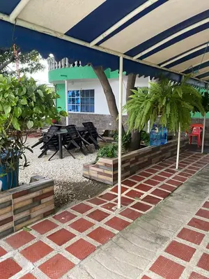 a patio with tables and potted plants in a building at Casa ISABELLA - Playa dormida in Santa Marta