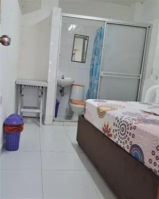 a bathroom with a bed and a sink and a toilet at Hostal Casa Lara in Cartagena de Indias