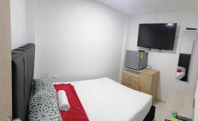 a bedroom with a bed and a flat screen tv at Hostel HA LUXURY in Cartagena de Indias