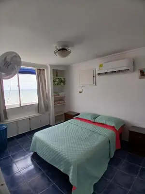 a bedroom with a bed and a large window at Apartamento con hermosa vista al mar en cartagena de indias in Cartagena de Indias