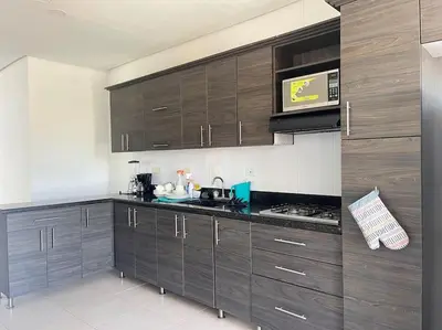 a kitchen with wooden cabinets and a counter top at Apartamento en Coveñas cerca al mar #204 in Coveñas