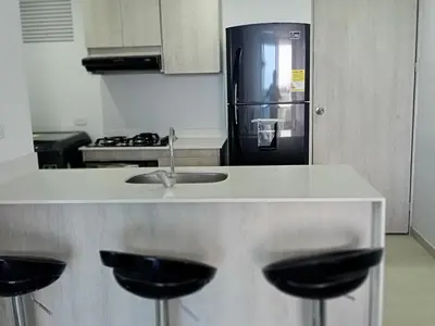 a kitchen with a counter with a sink and a refrigerator at Apto Vista Mar 2 cuadras Playa, Jaccuzi BBQ Wifi Parqueadero y Ascensor 7 Piso in Santa Marta