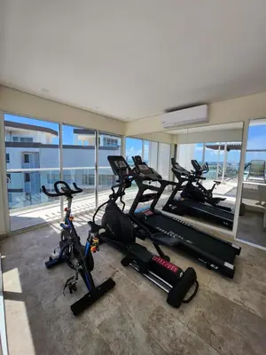 a gym with two treadmills and two exercise bikes at Dominiqueplayaazul apto de lujo con Jacuzzi privado en balcon in Cartagena de Indias