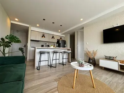 a kitchen and living room with a table in a room at Dominiqueplayaazul apto de lujo con Jacuzzi privado en balcon in Cartagena de Indias