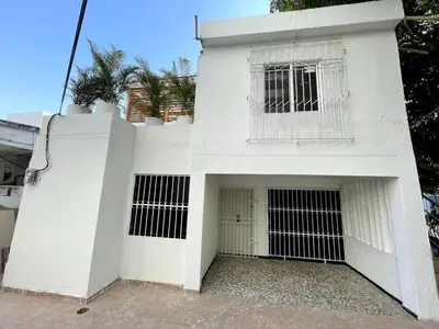 a white building with a door and a window at Wonderful trinity beach house in crespo. in Cartagena de Indias