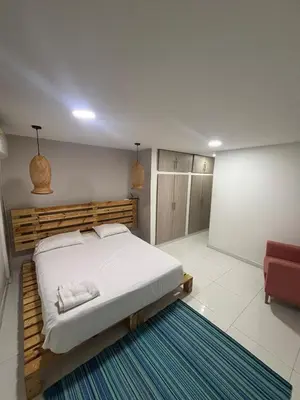 a bedroom with a large bed and a red chair at Wonderful trinity beach house in crespo. in Cartagena de Indias