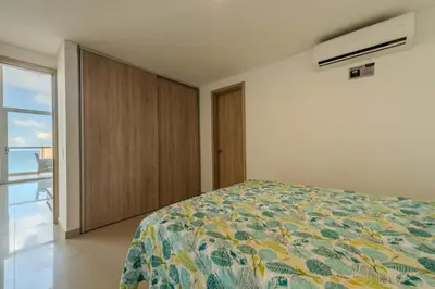 a bedroom with a bed and a closet and a window at amor por cartagena in Cartagena de Indias