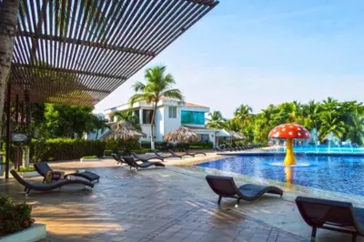 a pool with chairs and an umbrella next to a resort at * * Magnífico * * apto en la playa * *Costazul 405 in Santa Marta