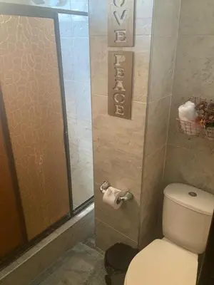 a bathroom with a toilet and a glass shower door at Habitación en apartamento compartido al frente del cc Unico in Barranquilla