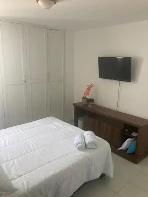 a bedroom with a bed and a flat screen tv at Habitación en apartamento compartido al frente del cc Unico in Barranquilla