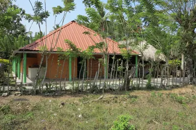 a house with a red roof and a fence at Casa Santa María in El Porvenir