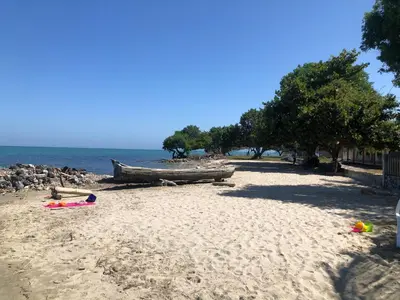 a sandy beach with a boat on the shore at Casa Santa María in El Porvenir