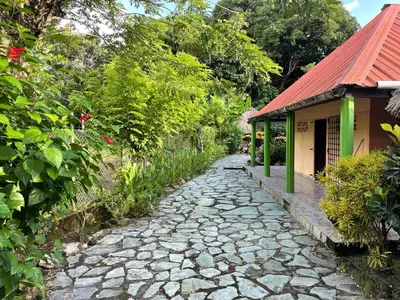 a stone path next to a building with a red roof at Casa Santa María in El Porvenir