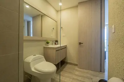 a bathroom with a toilet and a sink and a mirror at DQ1102 Hermoso con Jacuzzi priv y Vista increíble - 10 min Centro Historico in Cartagena de Indias