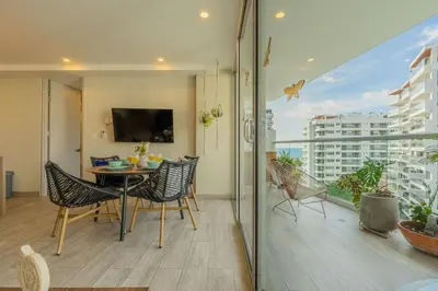 a room with a table and chairs and a balcony at DQ1102 Hermoso con Jacuzzi priv y Vista increíble - 10 min Centro Historico in Cartagena de Indias