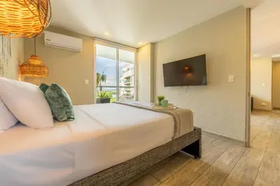 a bedroom with a large bed with a large window at DQ1102 Hermoso con Jacuzzi priv y Vista increíble - 10 min Centro Historico in Cartagena de Indias
